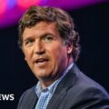 Tucker Carlson: Russian state media revels in Moscow visit